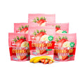 It's Nola Scrumptious Strawberry Banana's Six Pack Bundle is being displayed in a pyramid shape with two bananas and a few sliced strawberries under the center of the pyramid. The products are placed against a white background.